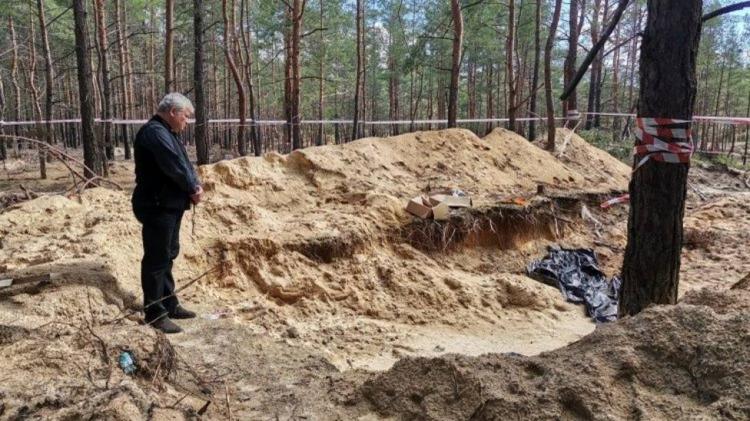 Ucrania: El enviado del Papa reza en la fosa común de Izyum